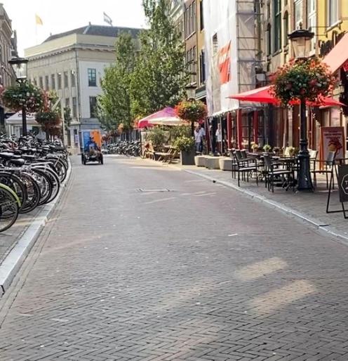 Oudkerkhof im September 2023, endlich völlig autofrei. Beachten Sie den pedalbetriebenen Lieferwagen in der Ferne. Radfahren ist in dieser Straße zu jeder Tageszeit erlaubt. Bild: Bicycle Dutch