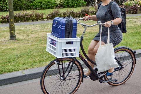 Woman on bicycle with suitcase